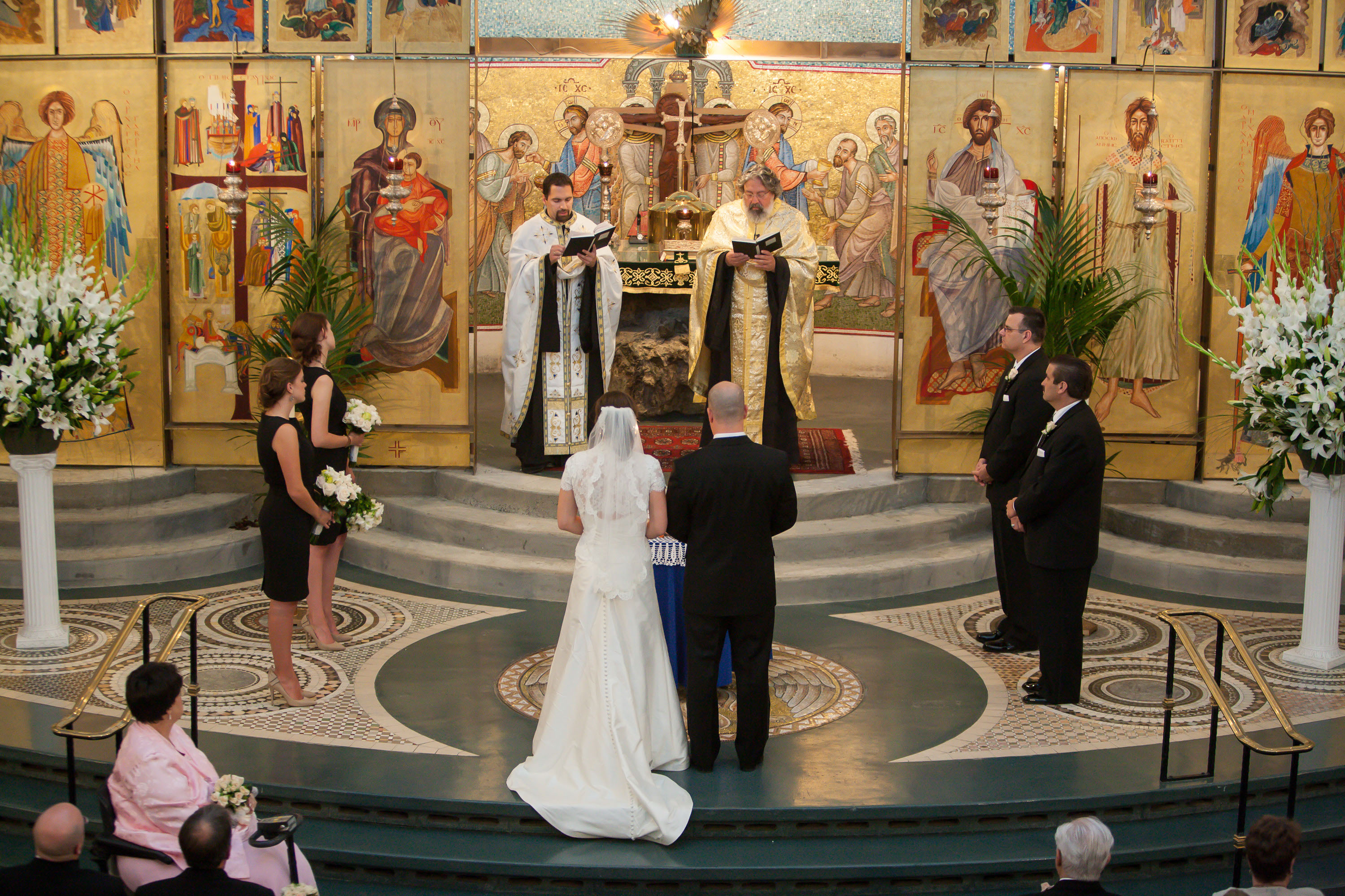 A couple is married amid the beautiful, richly colored artwork at the Holy Cross Greek Orthodox Church in Belmont