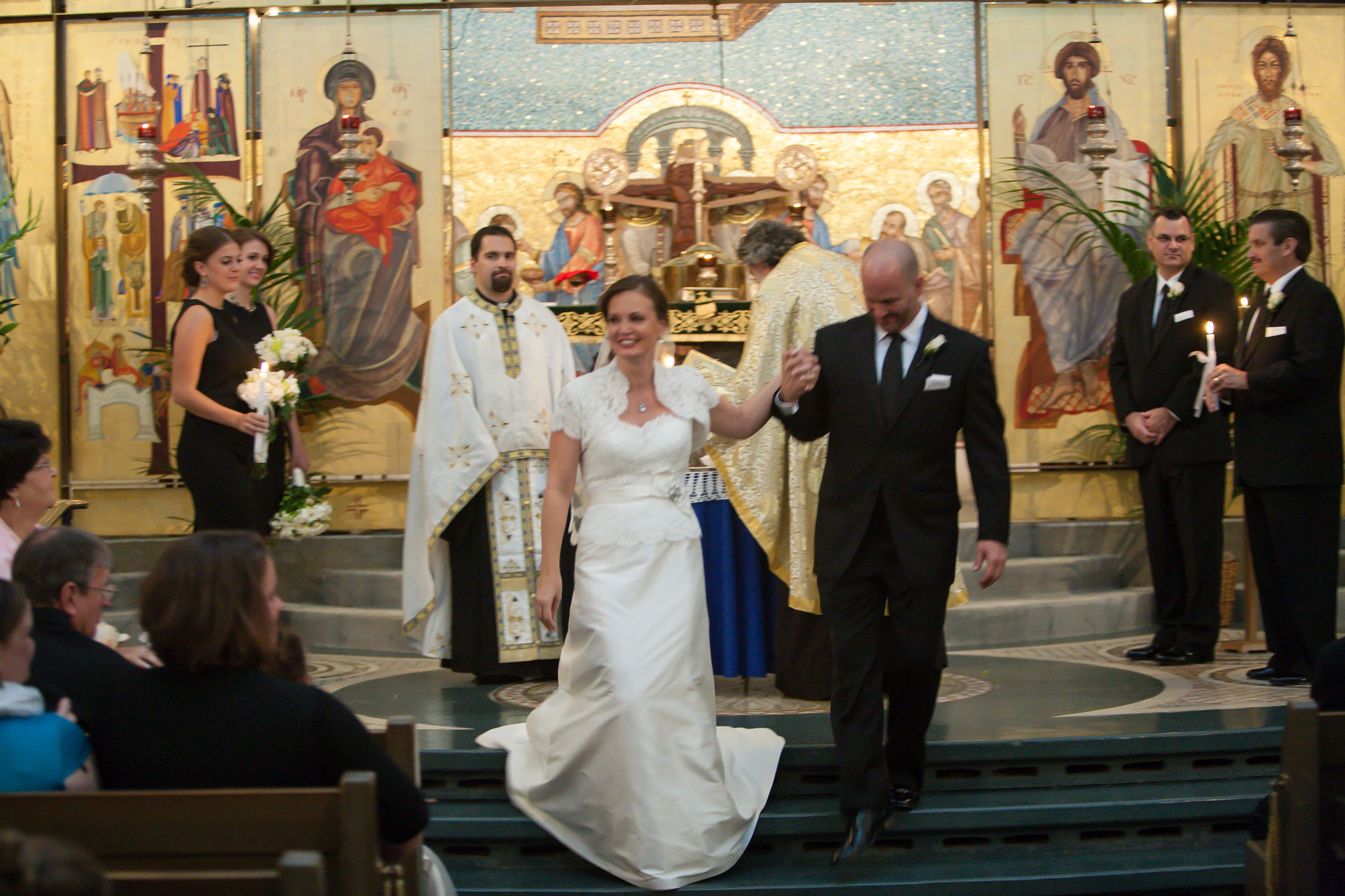 Bride and groom walk back down the aisle as husband and wife,  at the Holy Cross Greek Orthodox Church in Belmont
