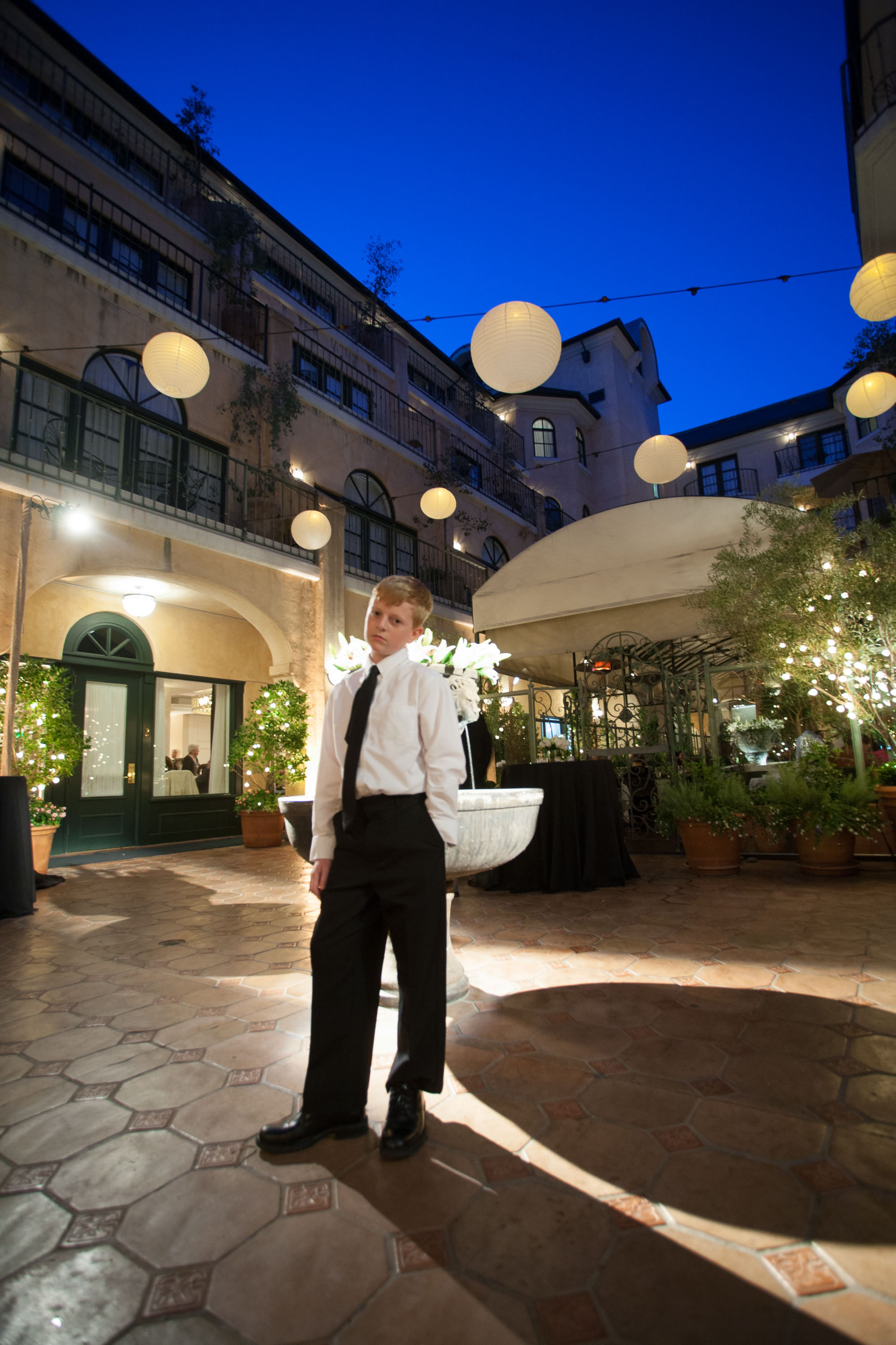A handsome young man poses in the twilit courtyard of the Garden Court Hotel in Palo Alto