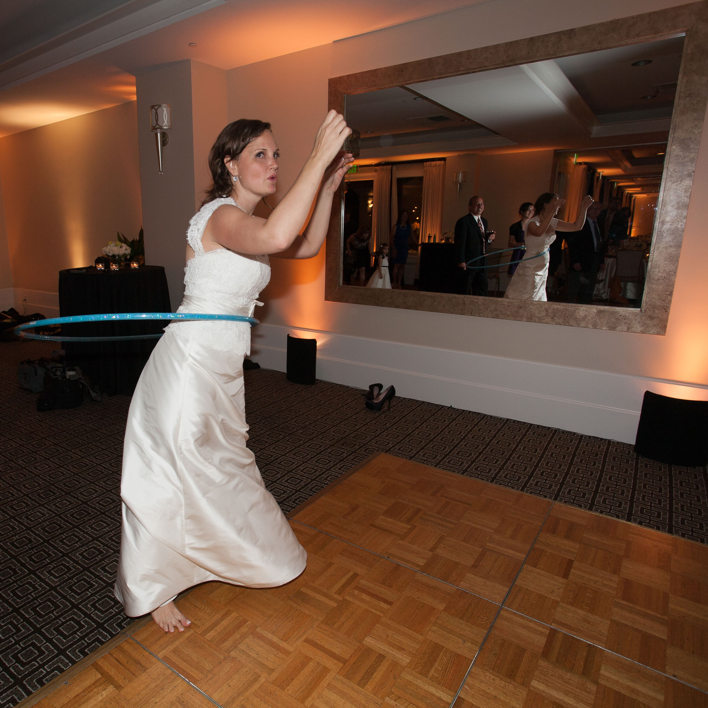 The bride hula-hoops in her wedding gown on the dance floor at the Garden Court Hotel in Palo Alto