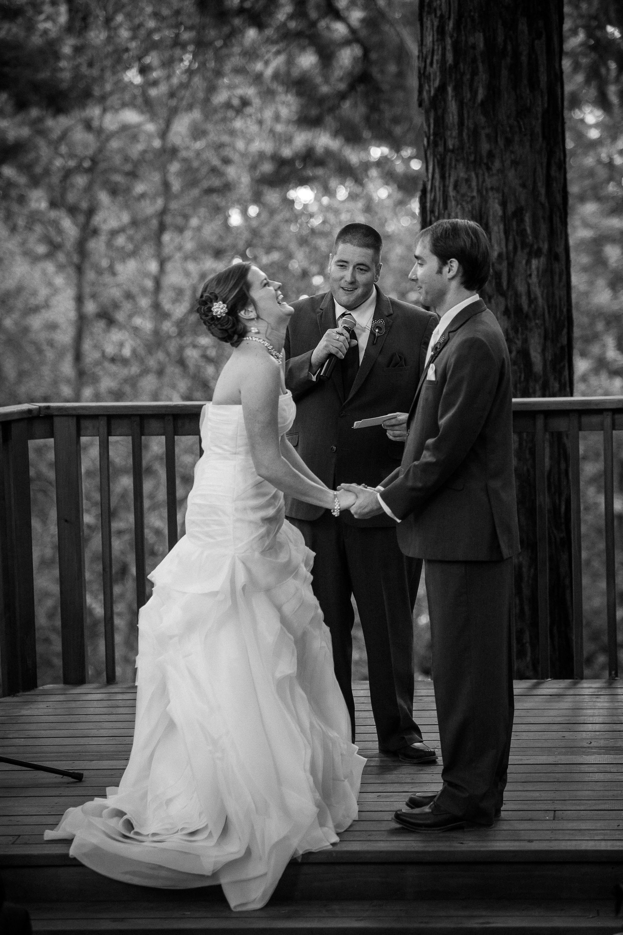 A bride laughs as her brother speaks during her wedding ceremony, at Pema Osel Ling in the Santa Cruz mountains