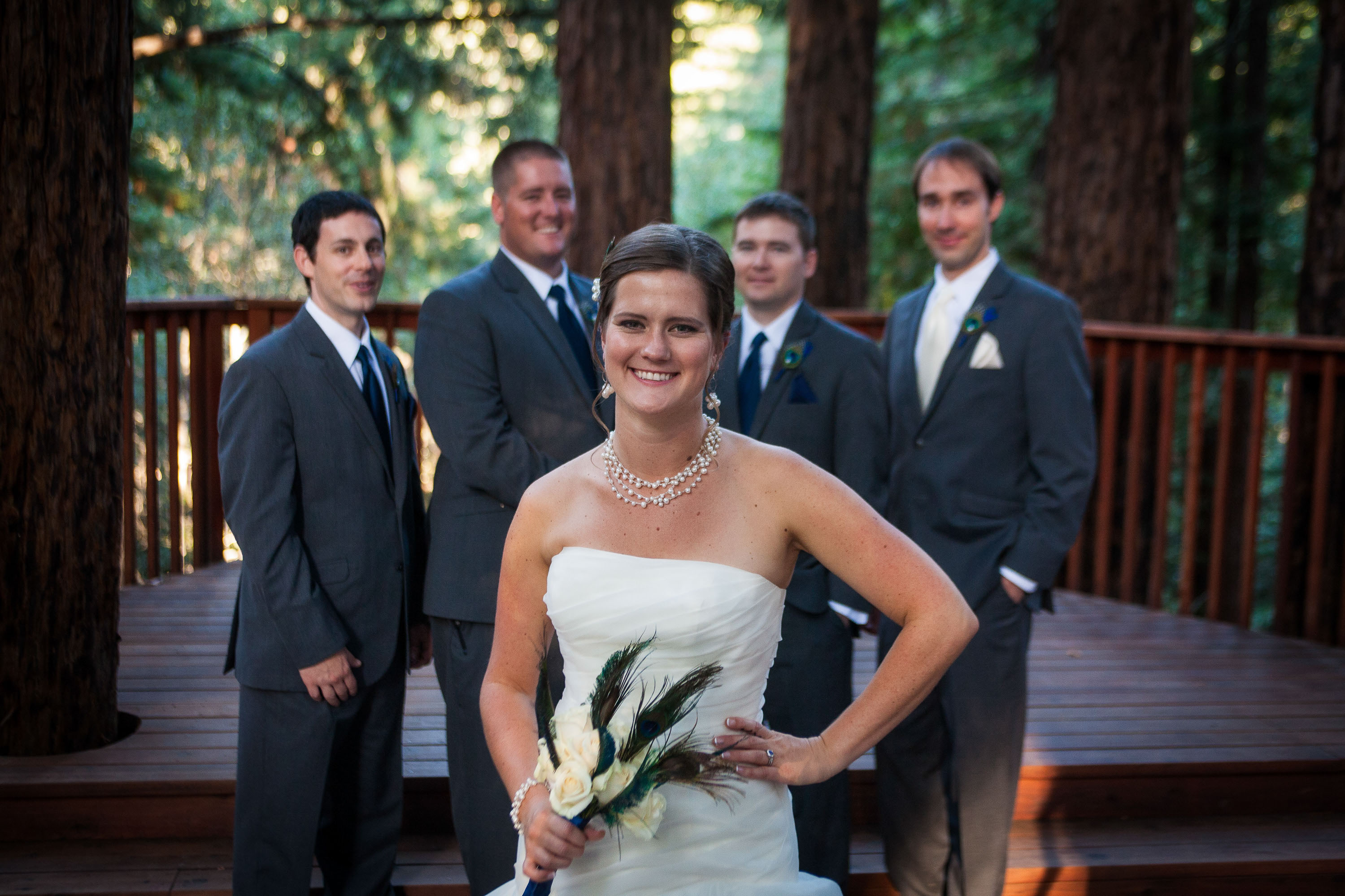 A confident bride smiling in front of her groomsmen at Pema Osel Ling in the Santa Cruz mountains