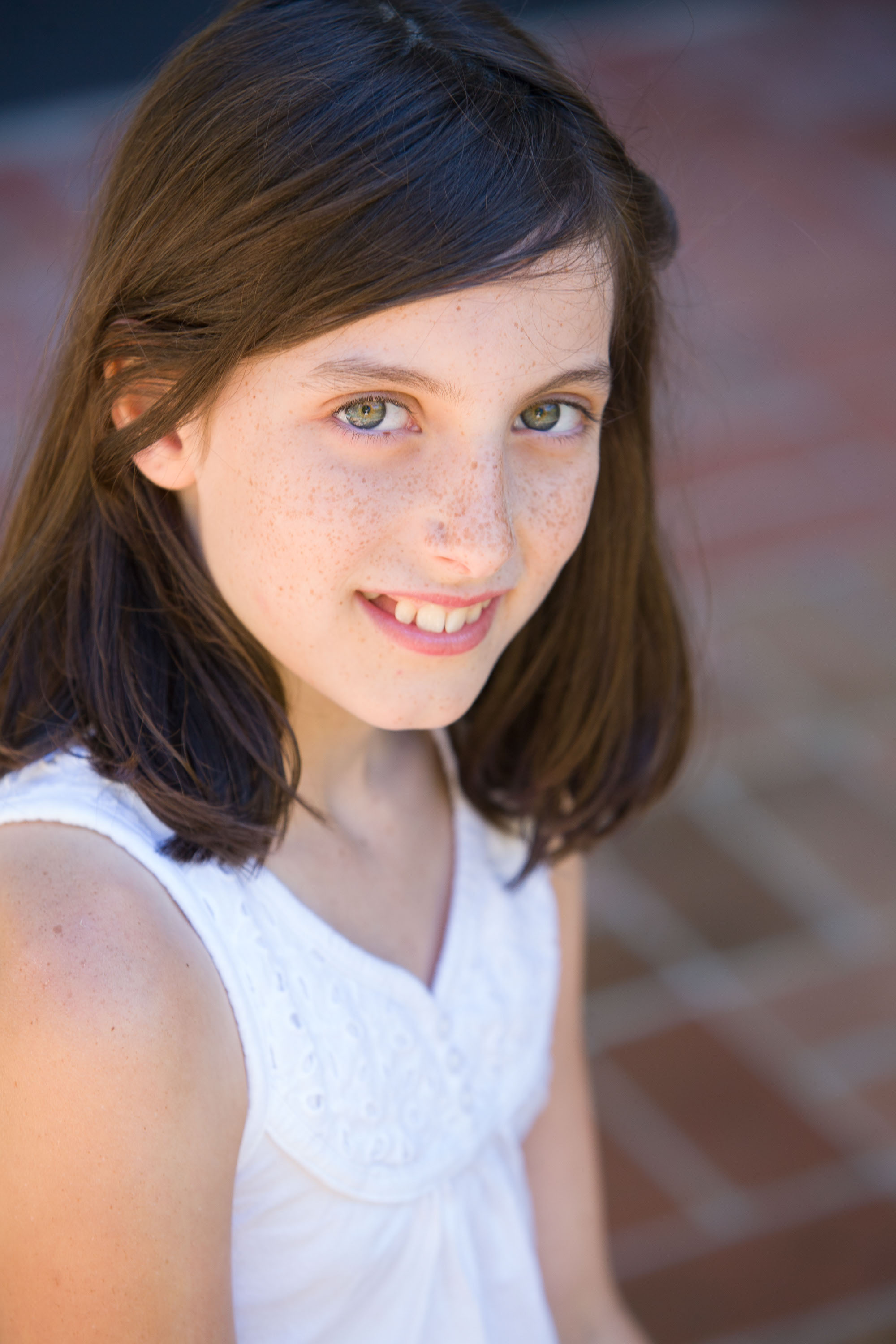 A sensitive close-up portrait of a tween girl with beautiful green eyes