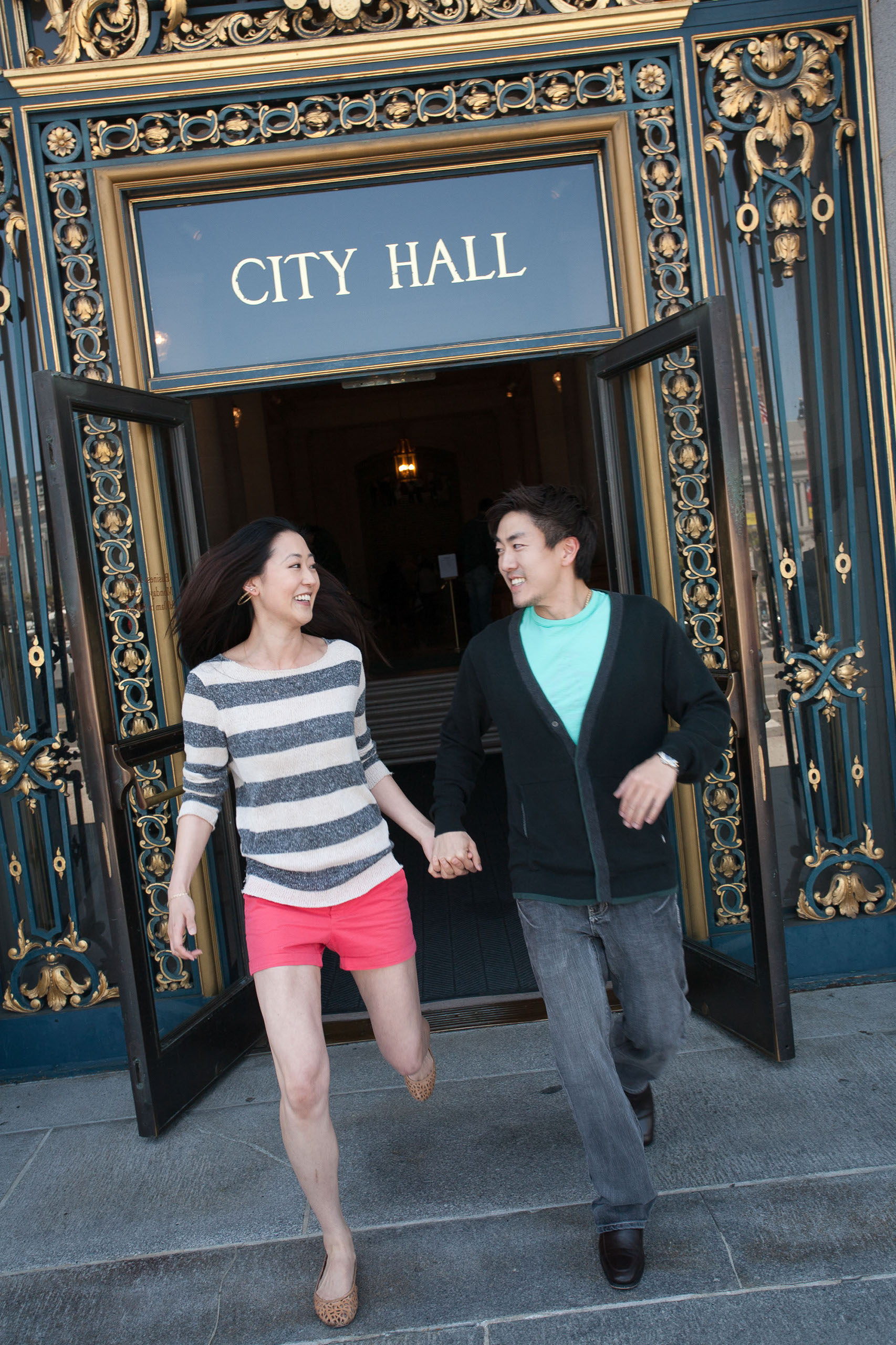 A jubilant couple runs out of San Franciso City Hall on their wedding day