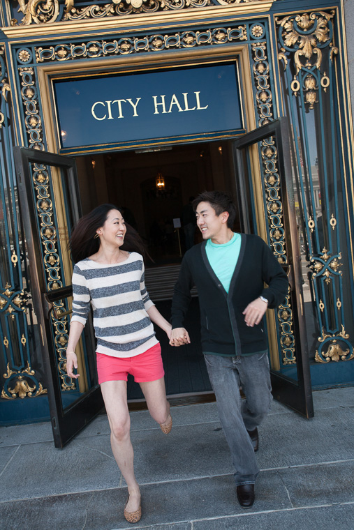 A stylish couple dashes out of City Hall at a San Francisco City Hall wedding. Just married!