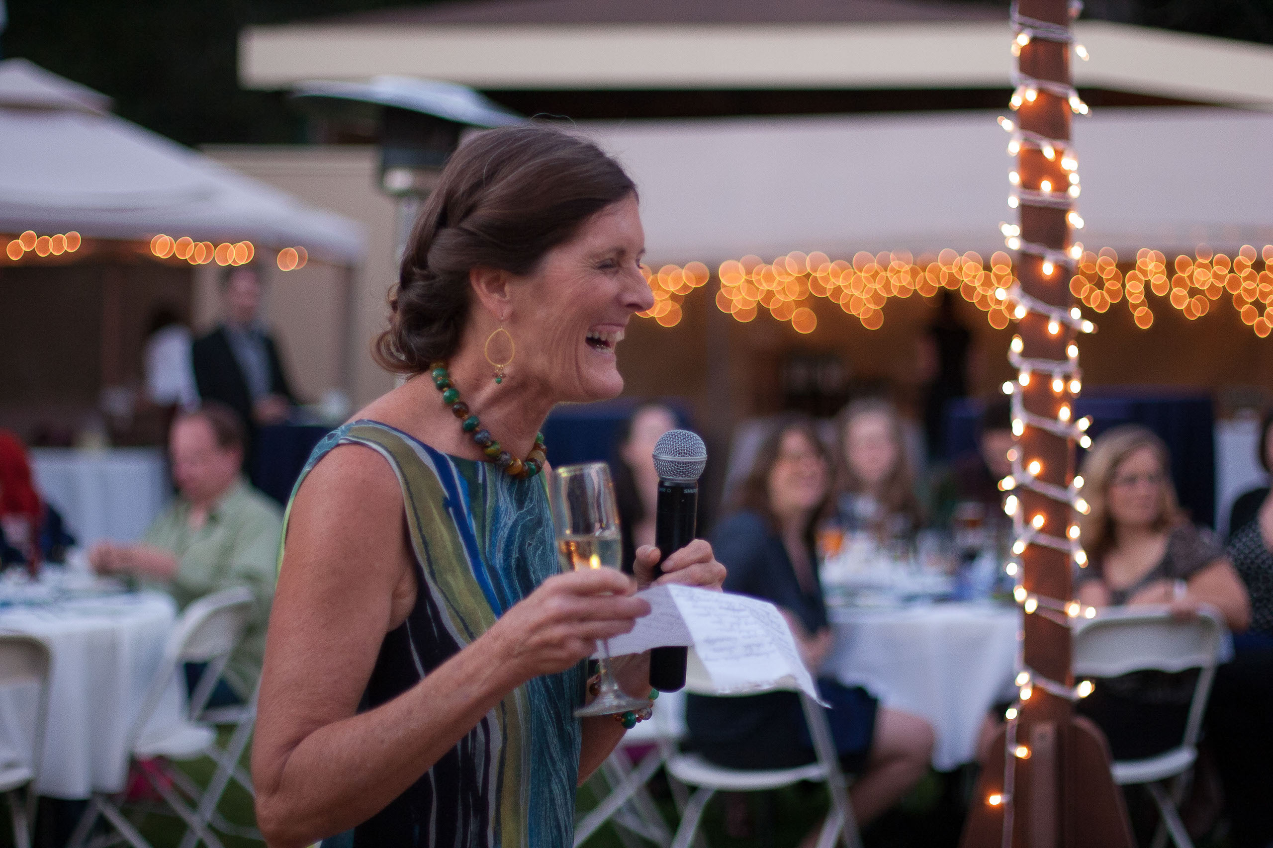 The bride's mom laughing as she toasts her daugher at her wedding at Pema Osel Ling Retreat Center in the Santa Cruz Mountains