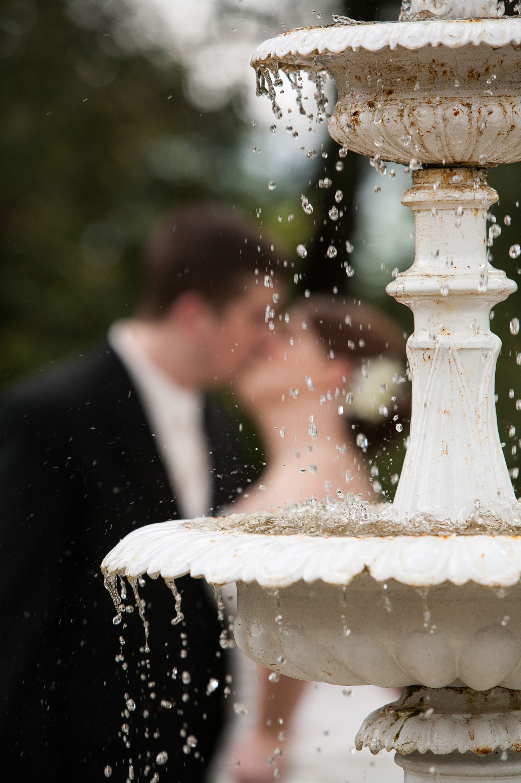 Couple kissing behind the romantic fountain at Madrona Manor in Healdsburg