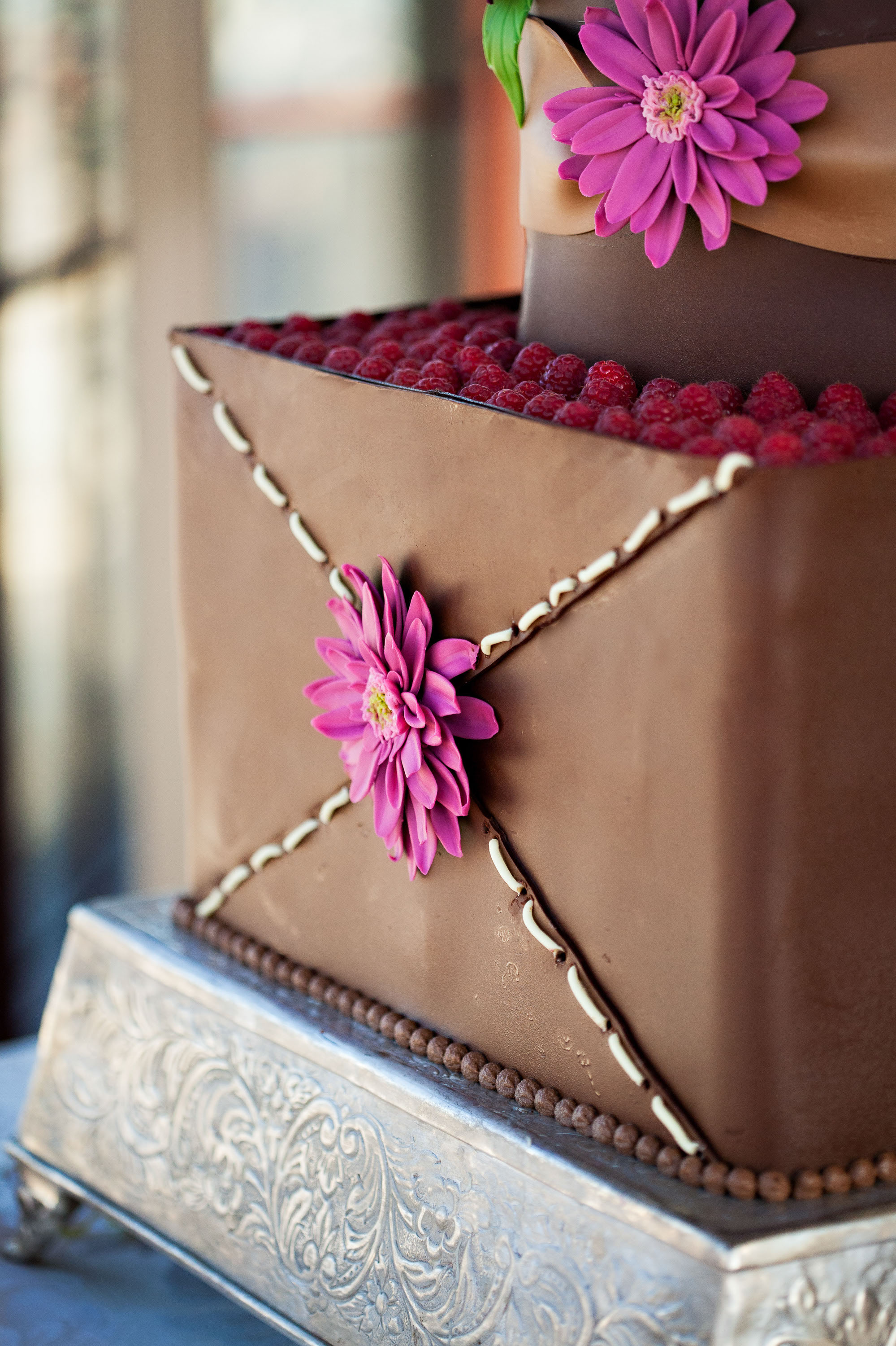 A close-up of the chocolate raspberry wedding cake with Gerber Daisy decorations,  at the St. Francis Hotel in San Francisco