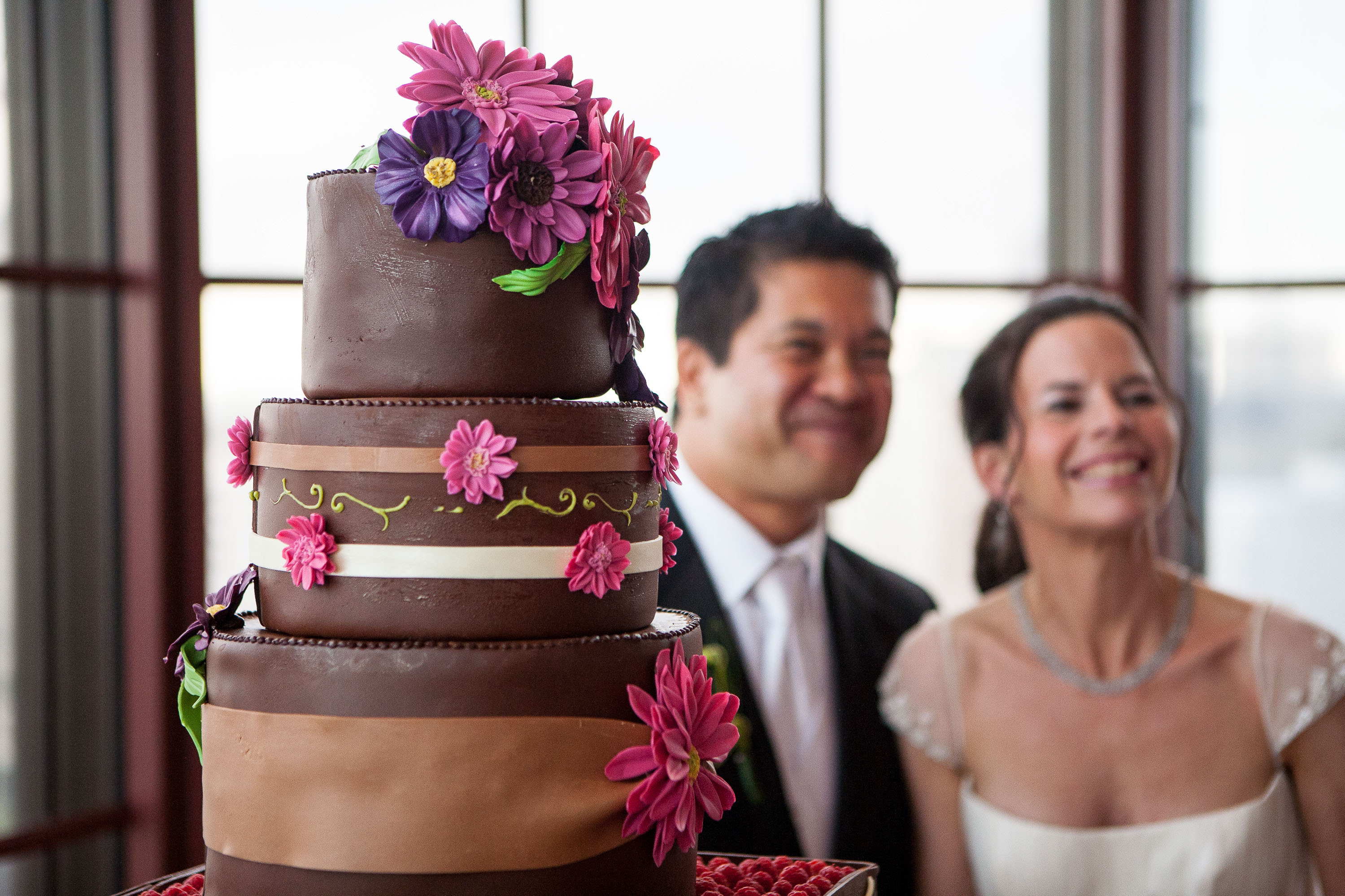 Detail of the cake with the couple smiling in the background, at the St. Francis Hotel in San Francisco